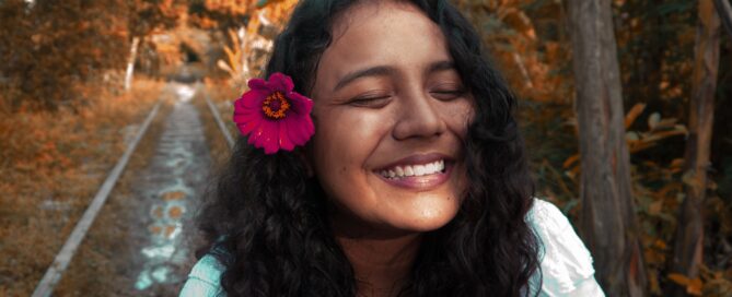 Image shows smiling girl with flower in her hair, wondering about correct terminology for her genitalia
