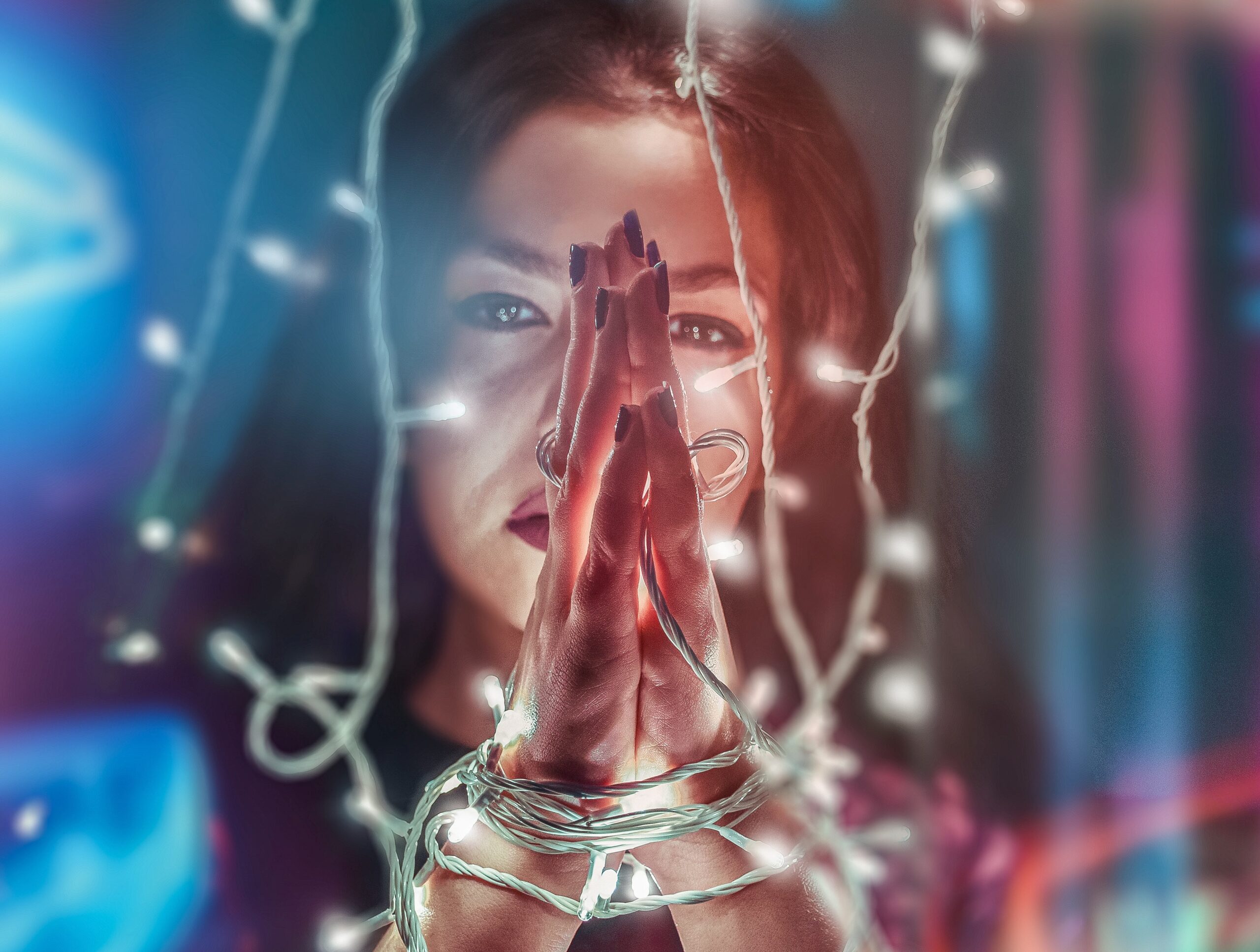 a-woman-practices-spiritual-bdsm-by-tying-her-hands-with-string-lights
