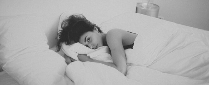 A woman experiencing low sexual desire lies in bed.