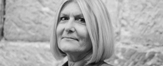 A woman with professional credentials smiles at the camera.