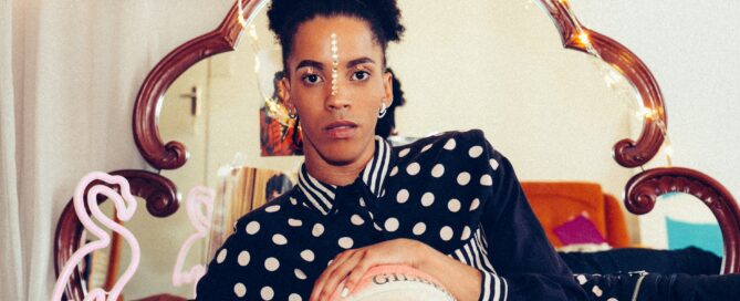 A trans woman poses in front of a mirror