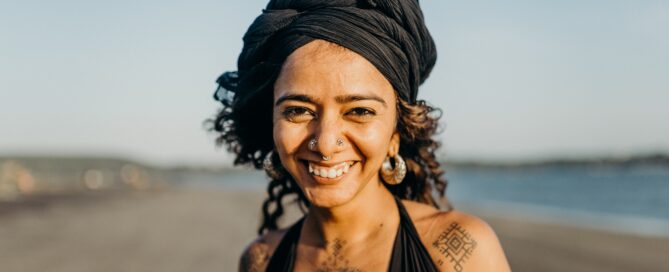 Image shows smiling woman on the beach