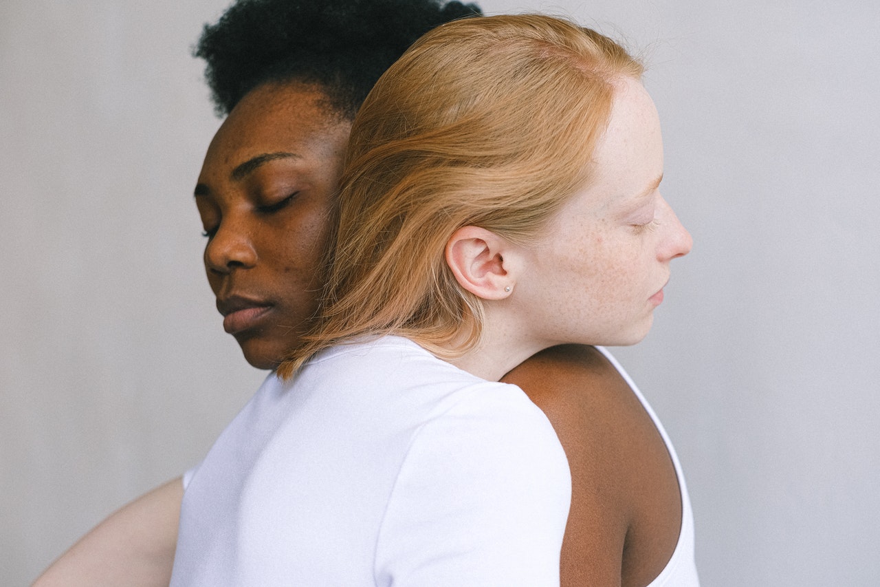 two people resting their heads on each other's shoulders