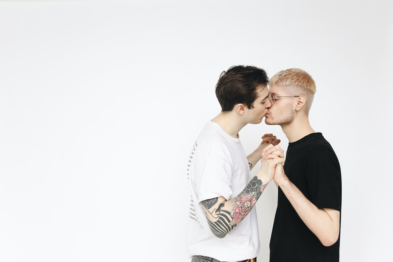 two men holding hands and kissing to show how pleasure products enhanced their relationship