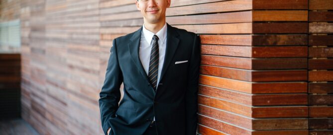 sexological bodywork professional stands next to a wall smiling