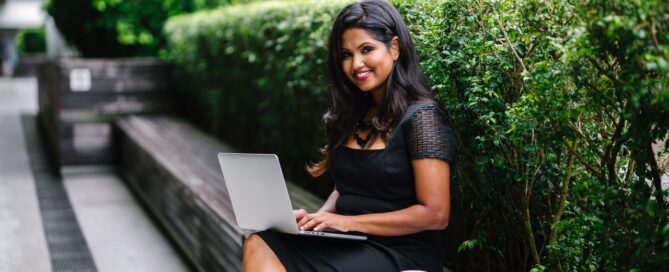 woman sitting on a bench with a laptop working with sexual shame in women