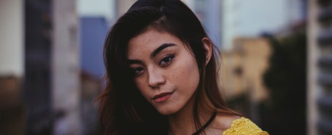 a girl in the city smiles at the camera after creating a vision board