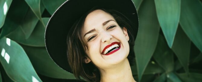 woman in a hat smiling because she learned the skill of time management
