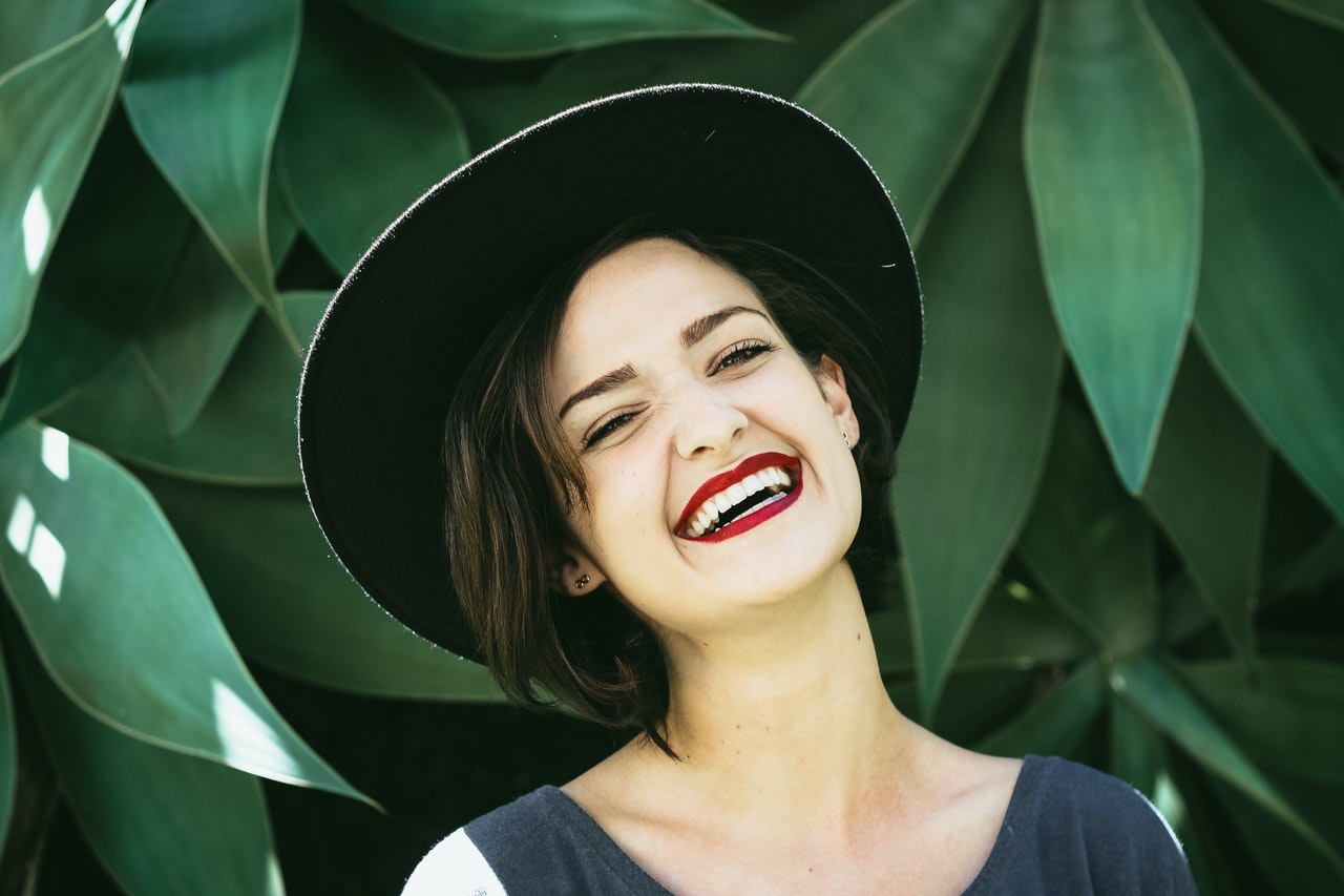 woman in a hat smiling because she learned the skill of time management