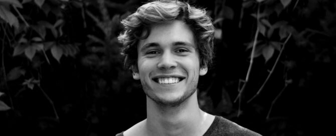 a black and white photo of a man smiling because he is a sex coach who knows about sexual supplements
