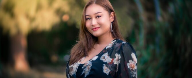 a woman with brown hair in a dress smiling outside while busting the myths of sex coaching