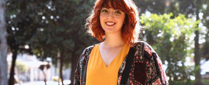 a woman standing with trees behind her smiling because it's masturbation months