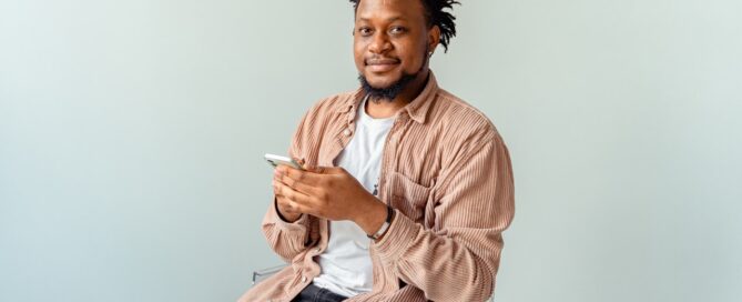 a man sits on a chair smiling because he learned how to beat performance anxiety
