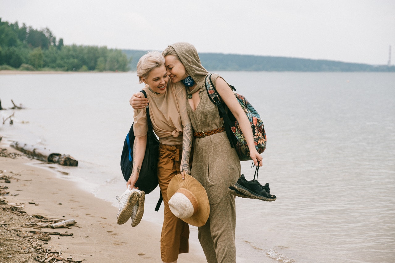 A happy Leo woman at the beach with her girlfriend