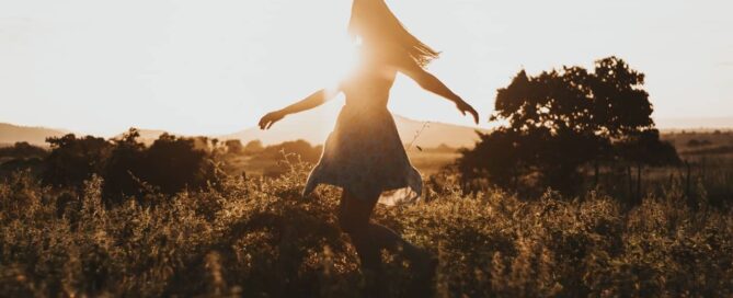 woman dances in field because she has found sustainable sex toys