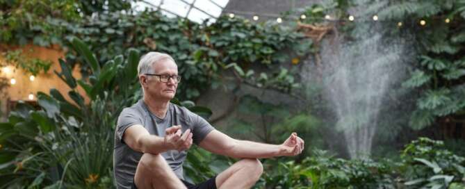 A man calming his nervous system by meditating in nature