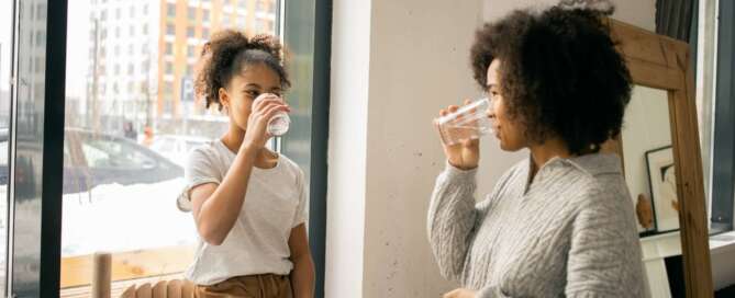 Parent and young child drink water after an age-appropriate discussion of sexuality