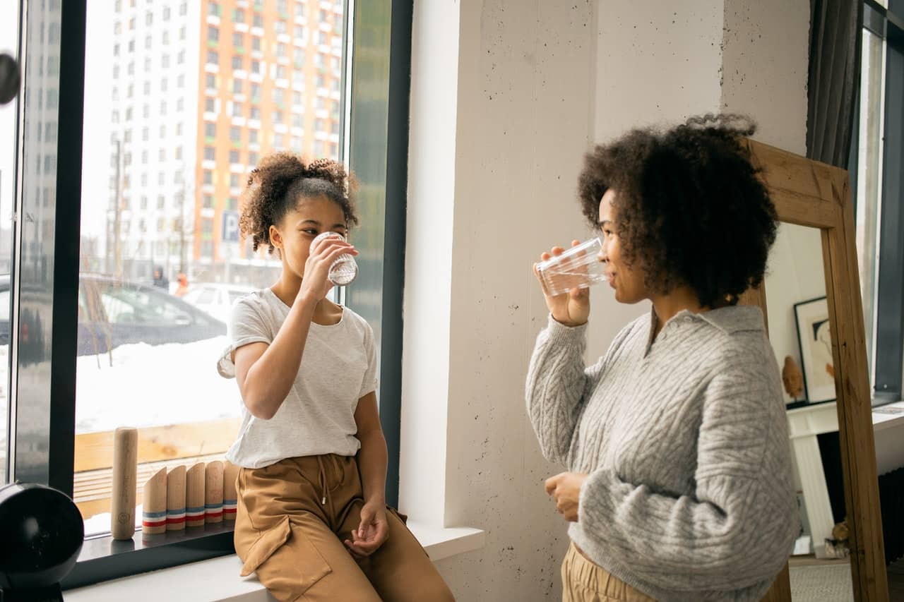 Parent and young child drink water after an age-appropriate discussion of sexuality