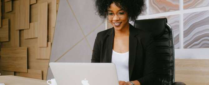 a sex coach smiling at her laptop while working