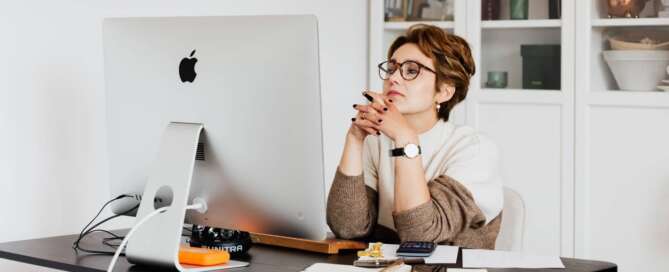 woman sitting at her desk pondering how to become a sex coach