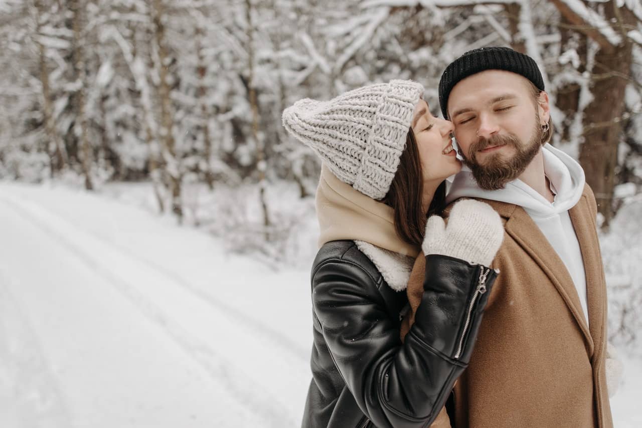 a happy couple in the snow after completing Sex coaching assignments for intimacy and connection in couples