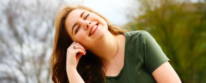 a woman smiling up at the sky because she learned how to receive pleasure