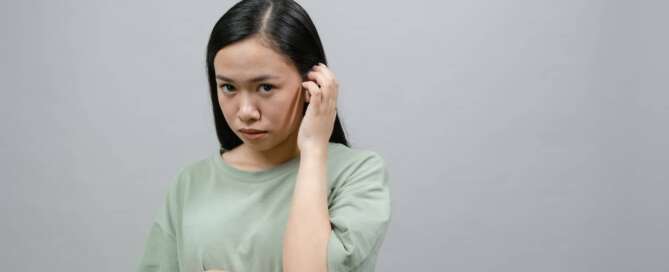 A woman experiencing sexual shame looks shyly at the camera.