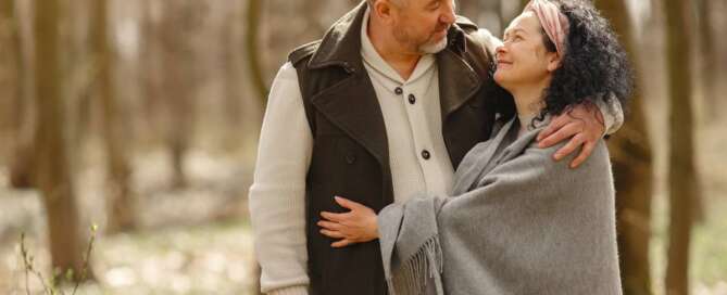 A happy couple embraces each other after receiving tranformational sex coaching.