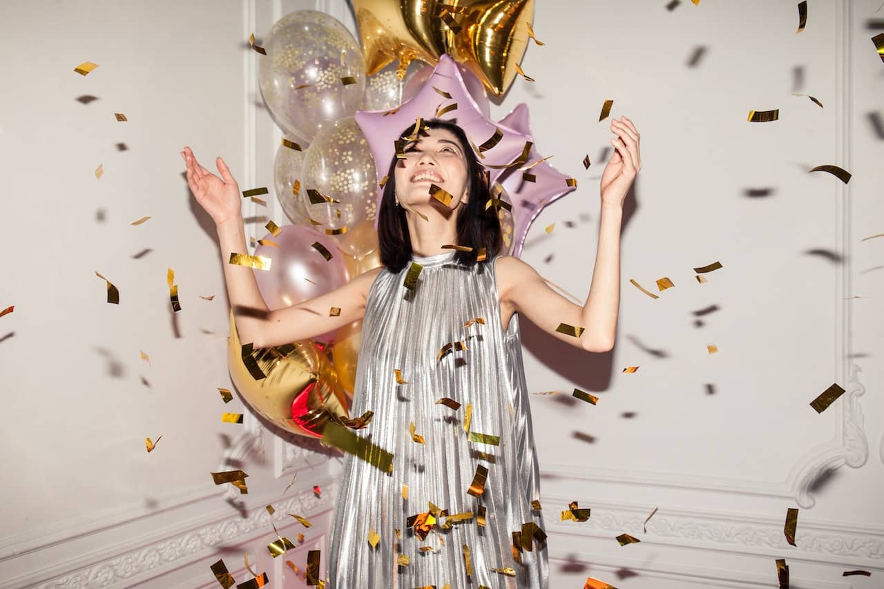 Woman celebrating with confetti because she is pivoting her career in the new year.