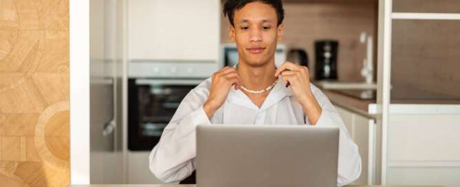 a person in a white shirt sitting at a table with a book and a laptop in front of them, figuring out how to know if they are ready for a career change.