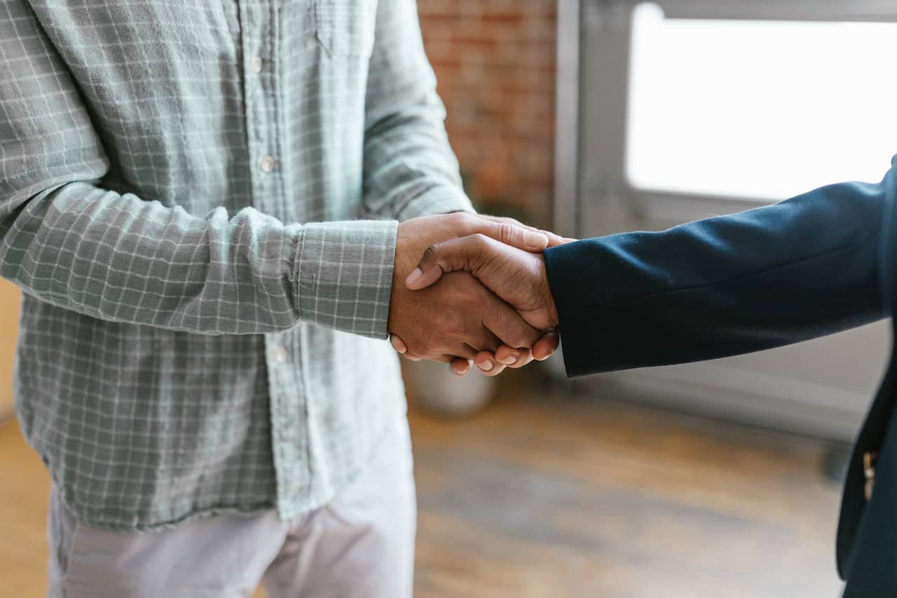 two hands embrace in a handshake after networking to benefit their client attraction strategy.